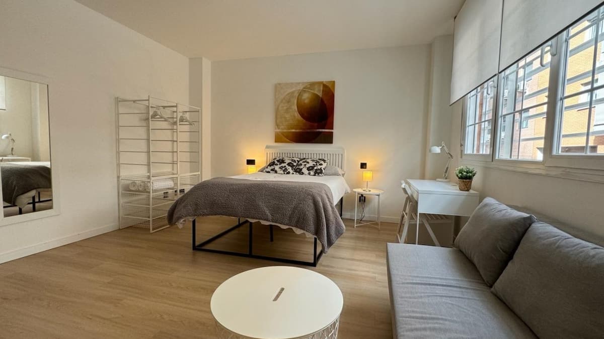 Amplio dormitorio con cama grande, sofá cama, escritorio de trabajo, Smart TV 50", aire acondicionado y gran ventanal acústico y con luz natural. 