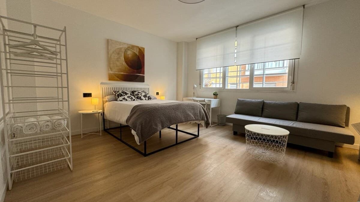 Amplio dormitorio con cama grande, sofá cama, escritorio de trabajo, Smart TV 50", aire acondicionado y gran ventanal acústico y con luz natural. 