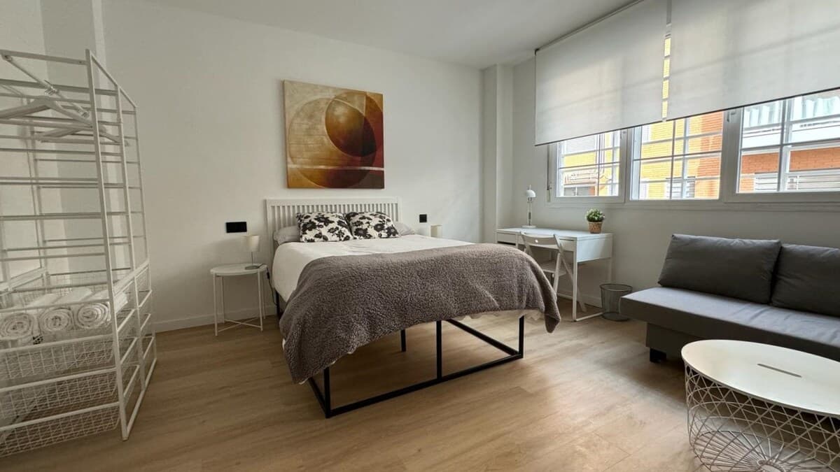 Amplio dormitorio con cama grande, sofá cama, escritorio de trabajo, Smart TV 50", aire acondicionado y gran ventanal acústico y con luz natural. 